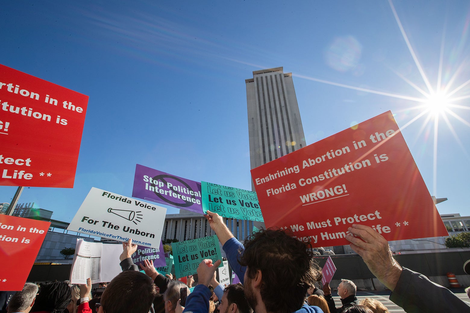 Protesters and counter-protesters hold up generic signs in support of democratic initiatives and opposed to abortion rights.