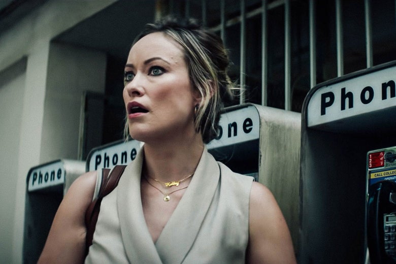 Olivia Wilde stands in front of some phone booths.