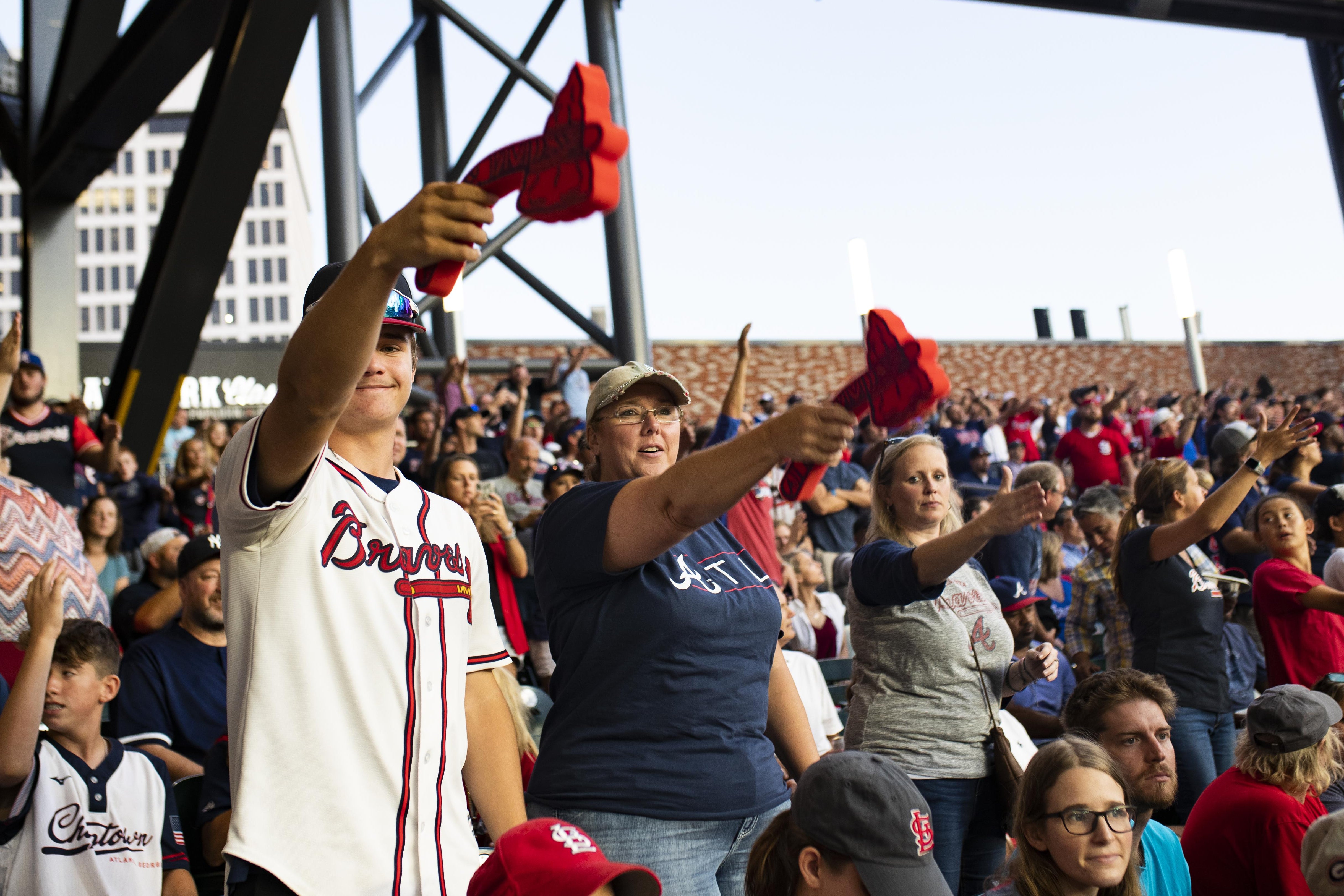 Fans in the stands hold out foam tomahawks or their right arms with hands in a "chop" position.