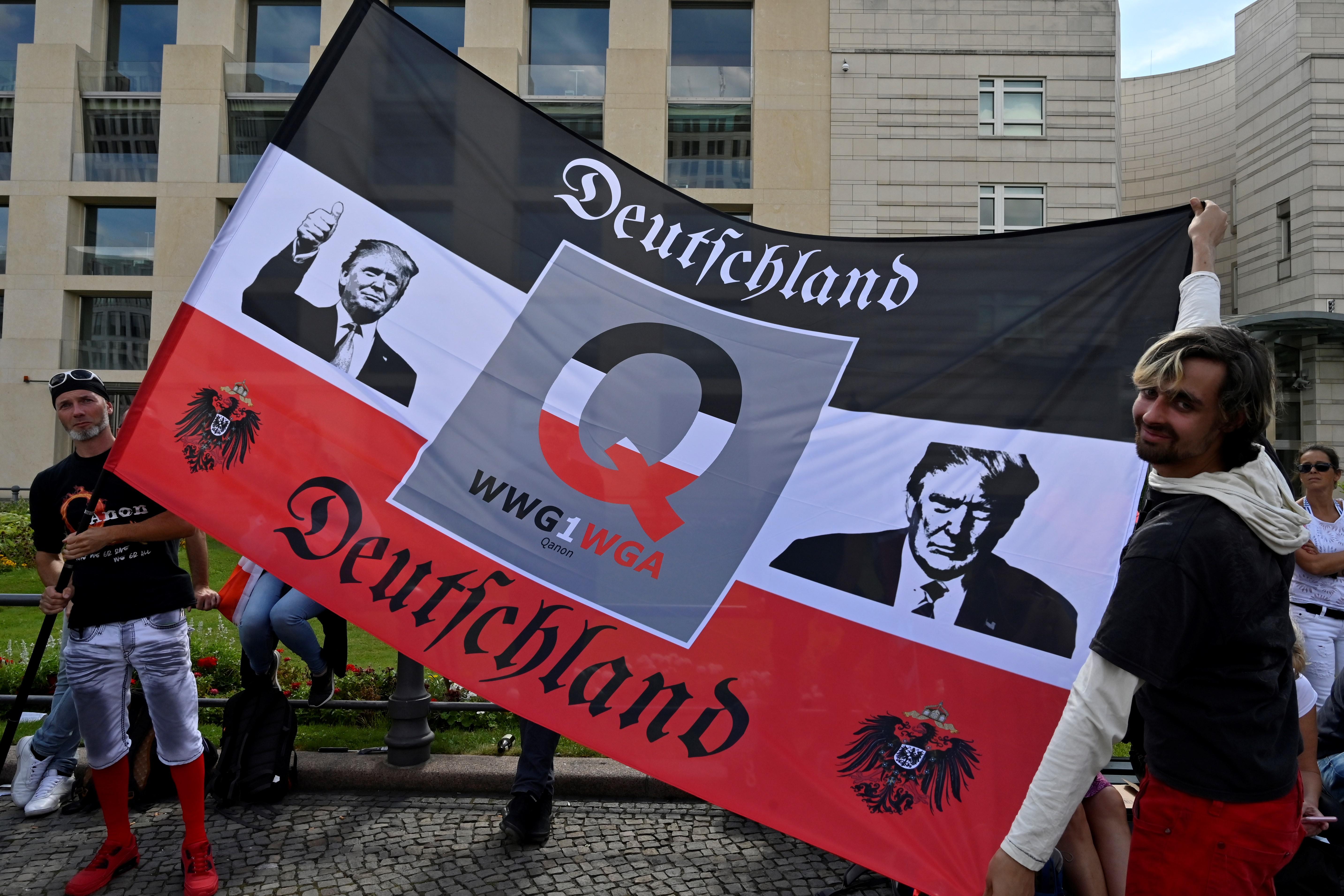 A flag featuring QAnon iconography and pictures of Trump.