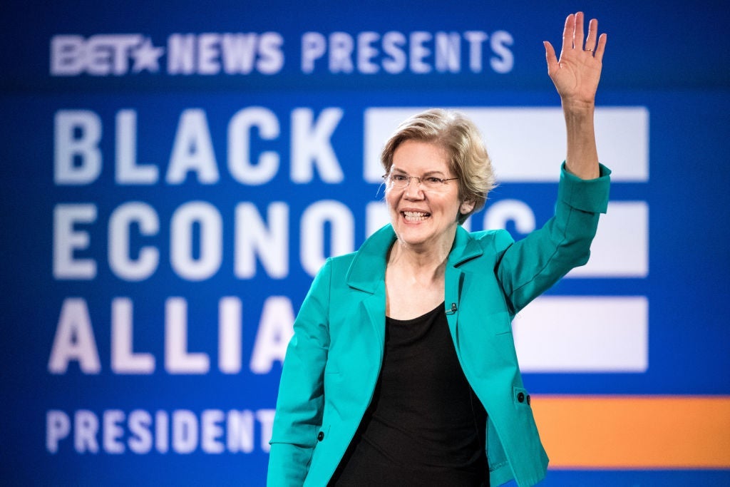 Warren waves to a crowd with her left hand.