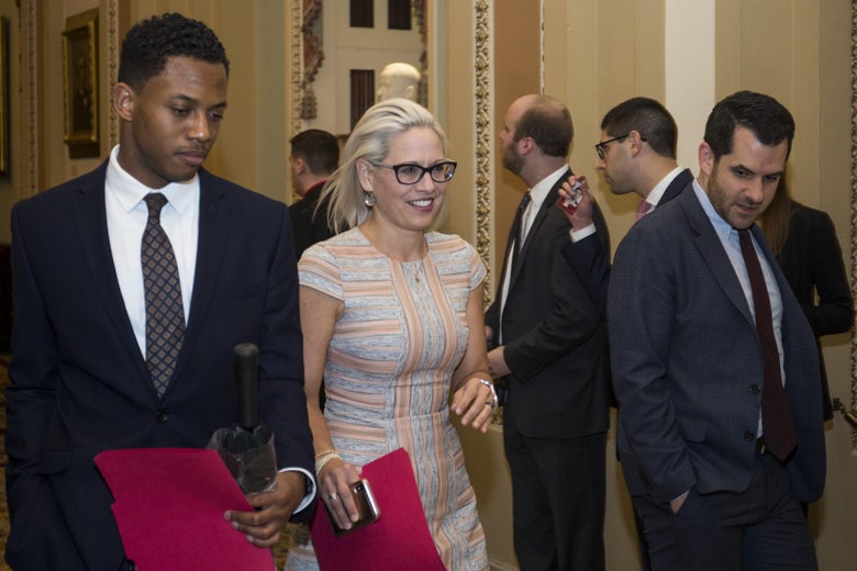Arizona Sen. Kyrsten Sinema walks near the Senate Chamber on Jan. 24. You can't see it in this photo, but she's wearing above-the-knee boots.