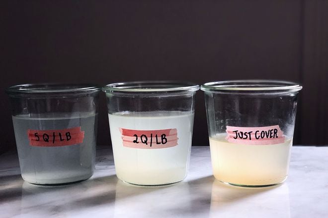 Three containers of murky pasta water sitting on a marble countertop from most to least transparent: 5q/lb, 2q/lb, "just cover."