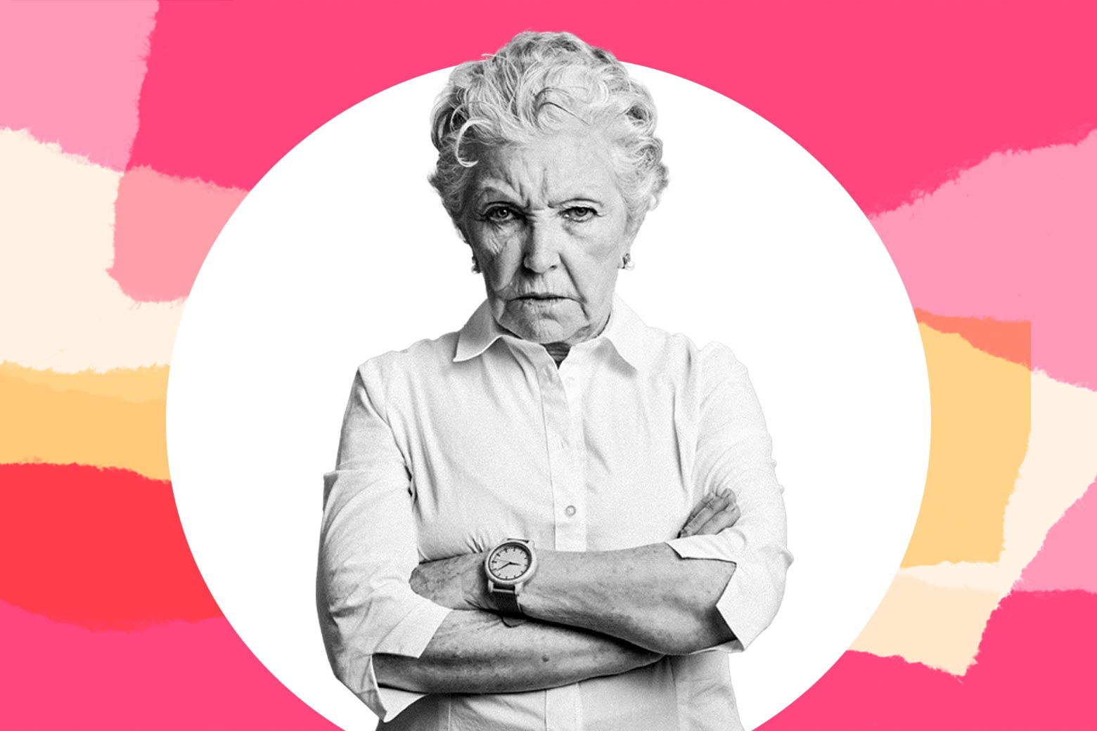A woman in her 70s standing with her arms crossed and a stern face.