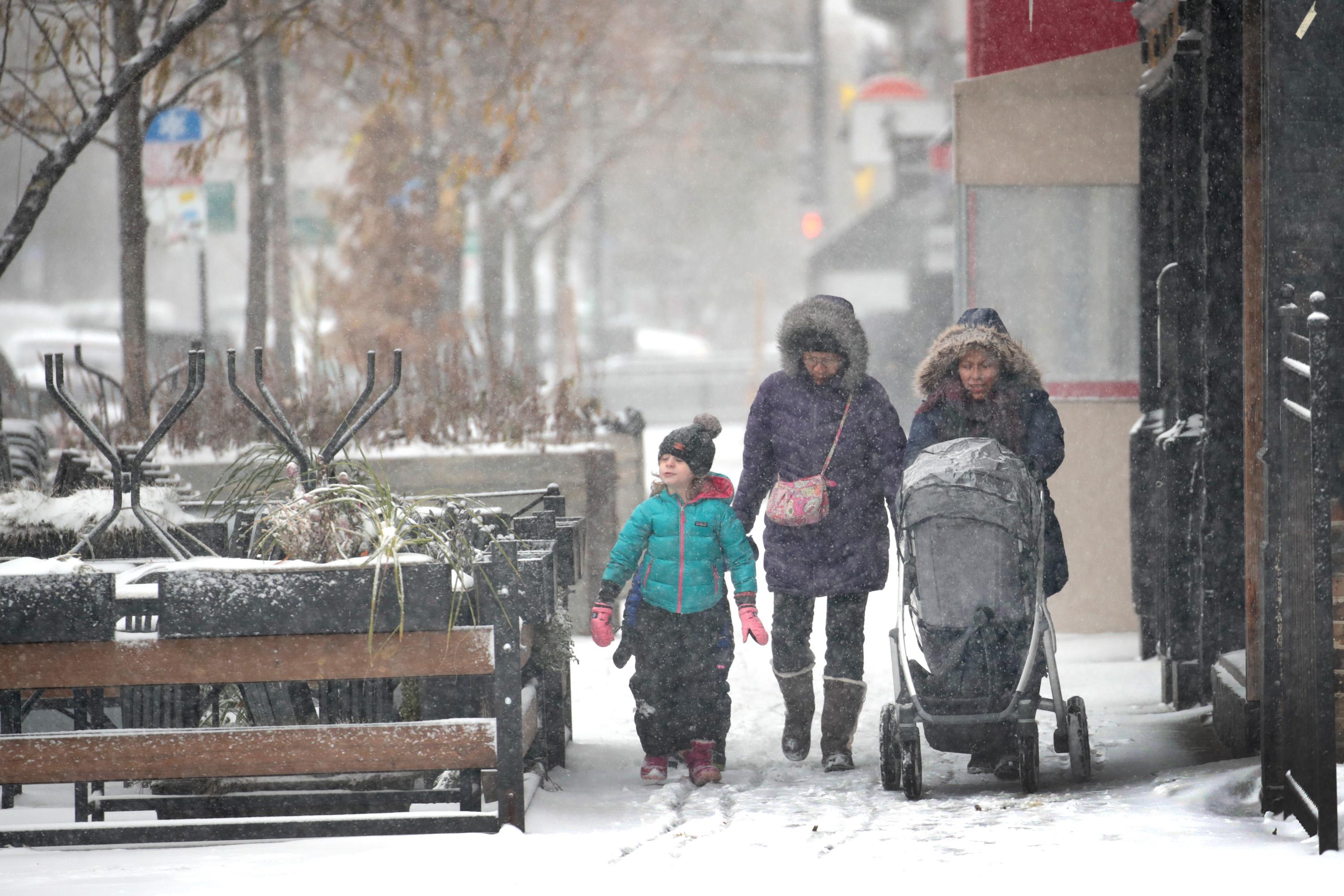 People navigate snow-covered sidewalks in Chicago.