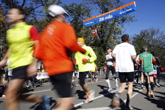 Runners pass the 26 mile marker sign while participating in one of several fun runs in and around Central Park, New York.