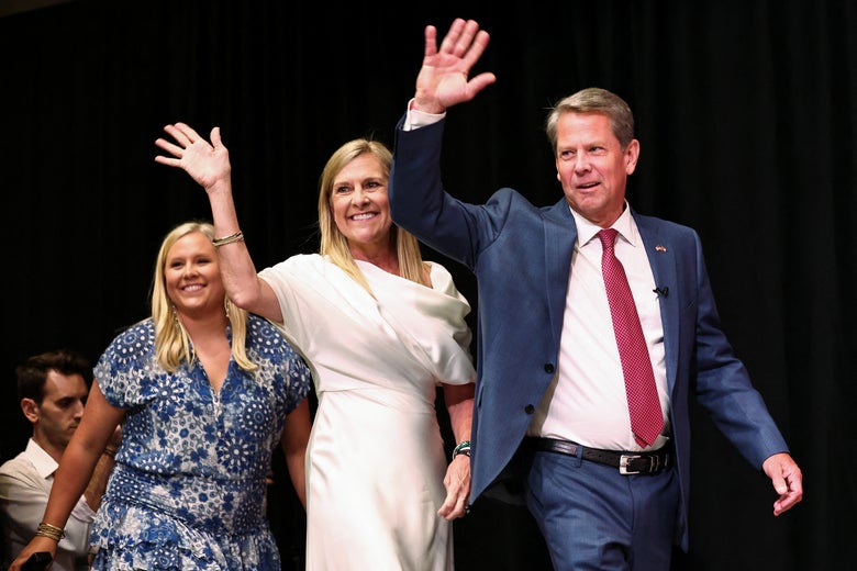 Gov. Brian Kemp walks on stage, waving, with his wife and children, to speak after winning the Republican gubernatorial primary in Georgia.