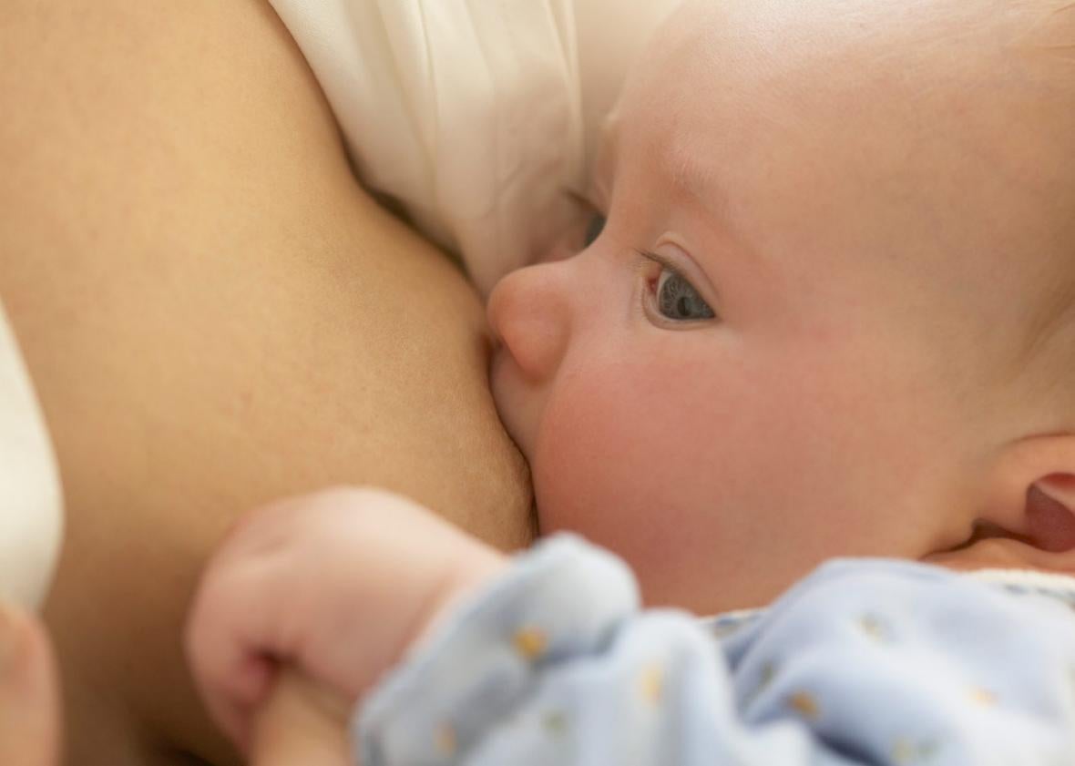 A woman breastfeeds her infant. 