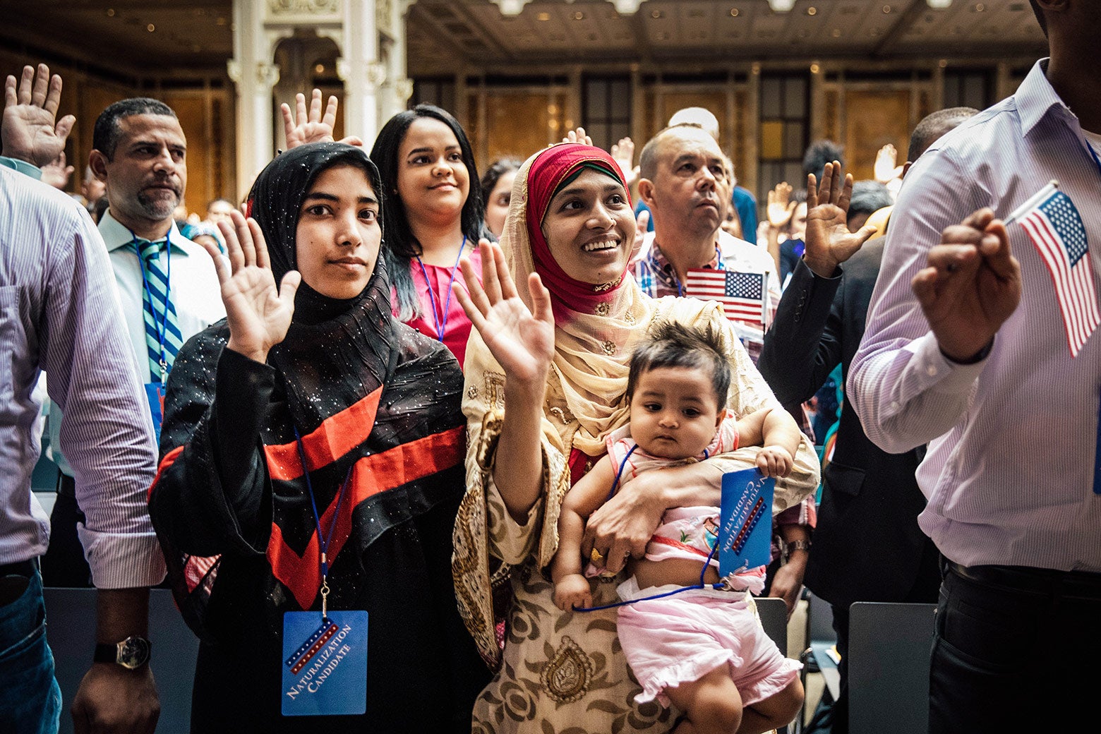 Mosammat Rasheda Akter, originally from Bangladesh, holds her 7-month-old daughter, Fahmida, as she recites the oath of allegiance during a naturalization ceremony.