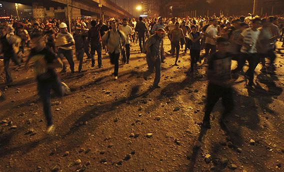 Anti-Mursi protesters run during clashes with members of the Muslim Brotherhood and supporters of ousted Egyptian President Mohamed Mursi near Maspero, Egypt's state TV and radio station, near Tahrir square in Cairo July 5, 2013.