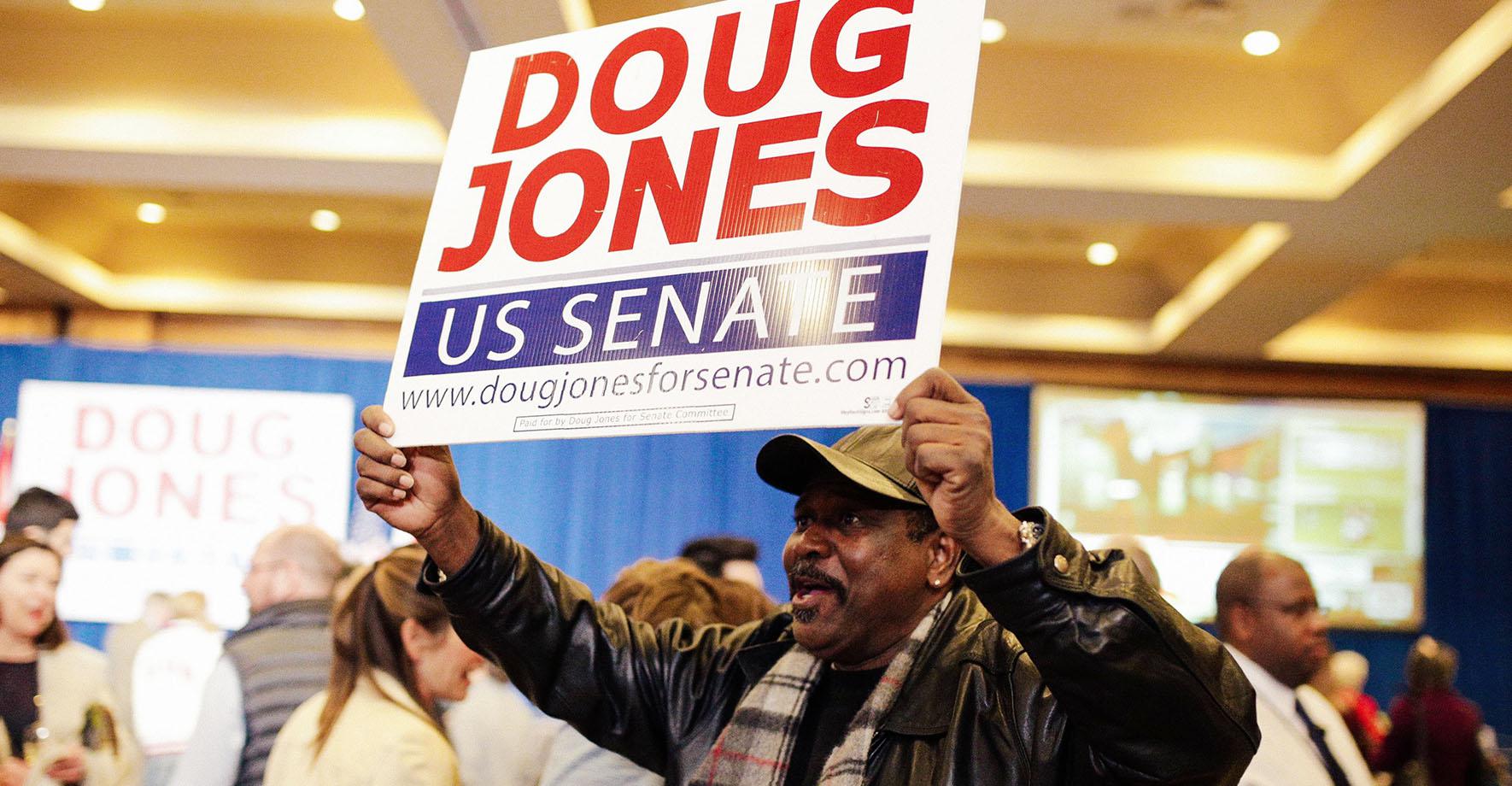 A supporter holds a sign during Democratic U.S. Senate candidate Doug Jones' election night party in Birmingham, Alabama, U.S. December 12, 2017.