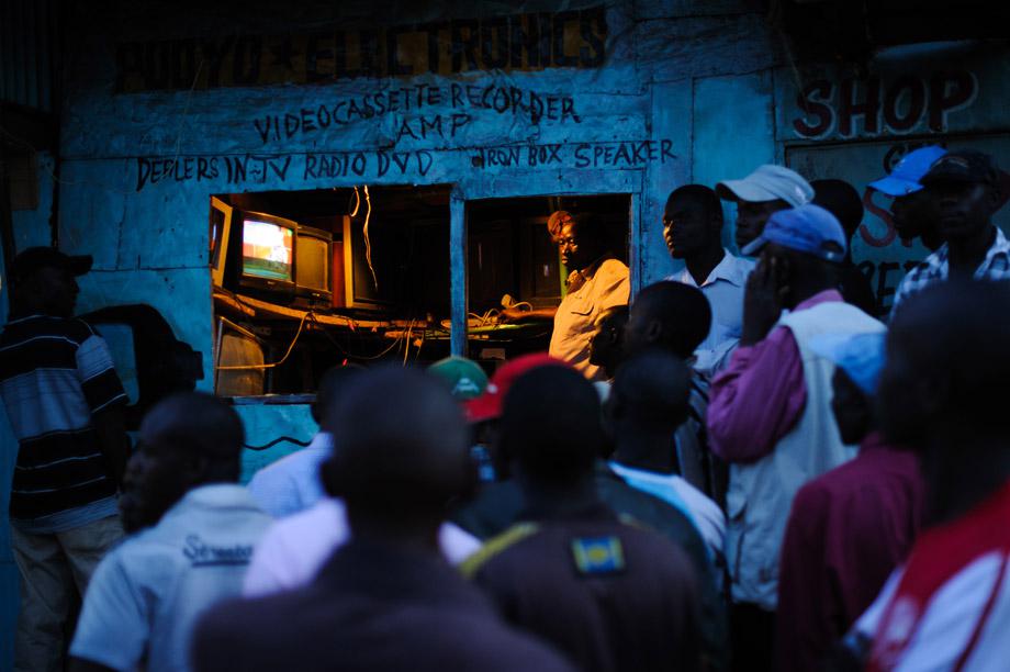 Men watch the incoming provisional election results on a television outside a shop in the Kibera slum of Nairobi, Kenya's capital, March 5, 2013. Kenya's deputy prime minister Uhuru Kenyatta, who faces an international crimes against humanity trial, took an initial lead in presidential elections today, the first since disputed polls five years ago sparked a wave of violence.