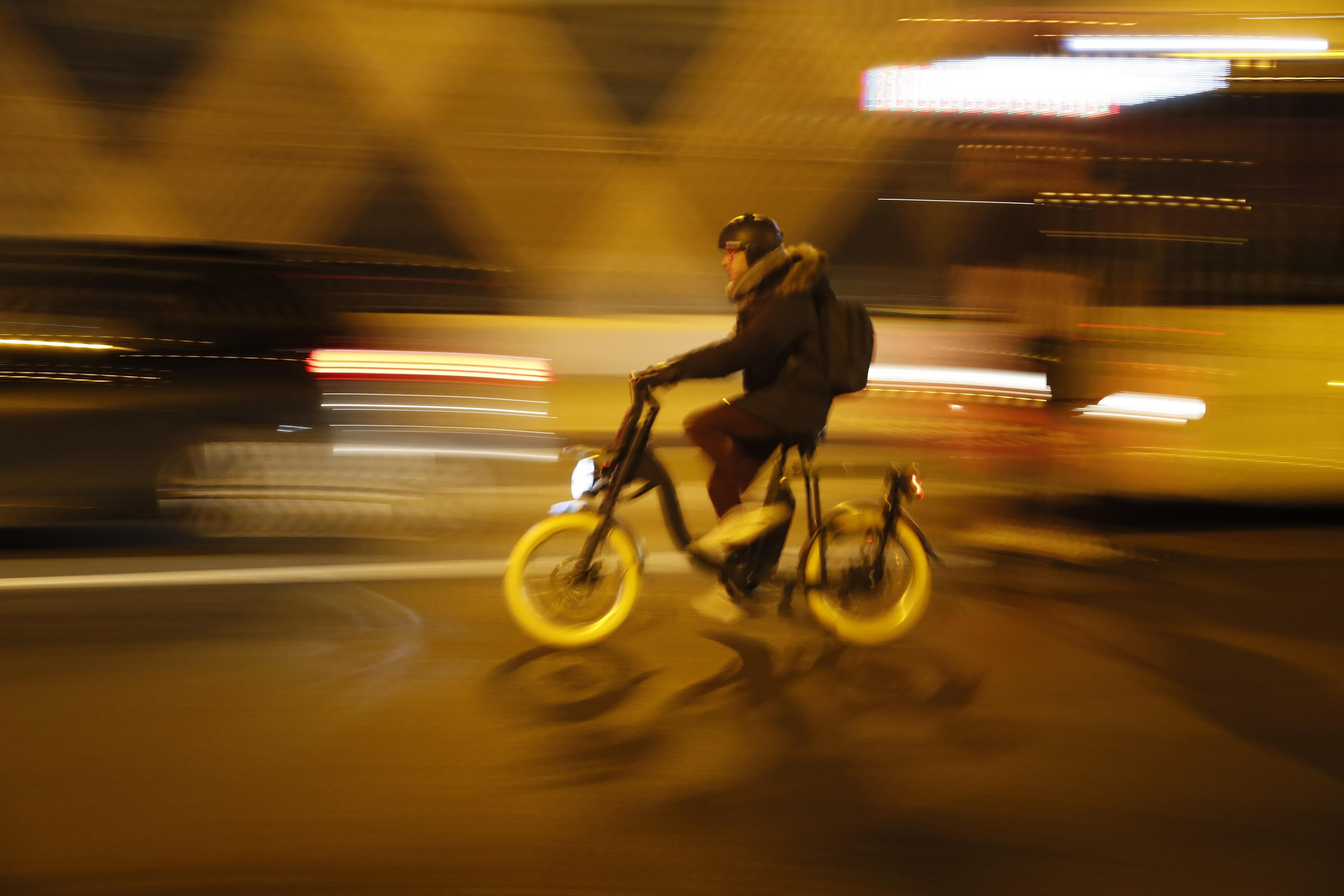 A man wearing a helmet rides a yellow bike.