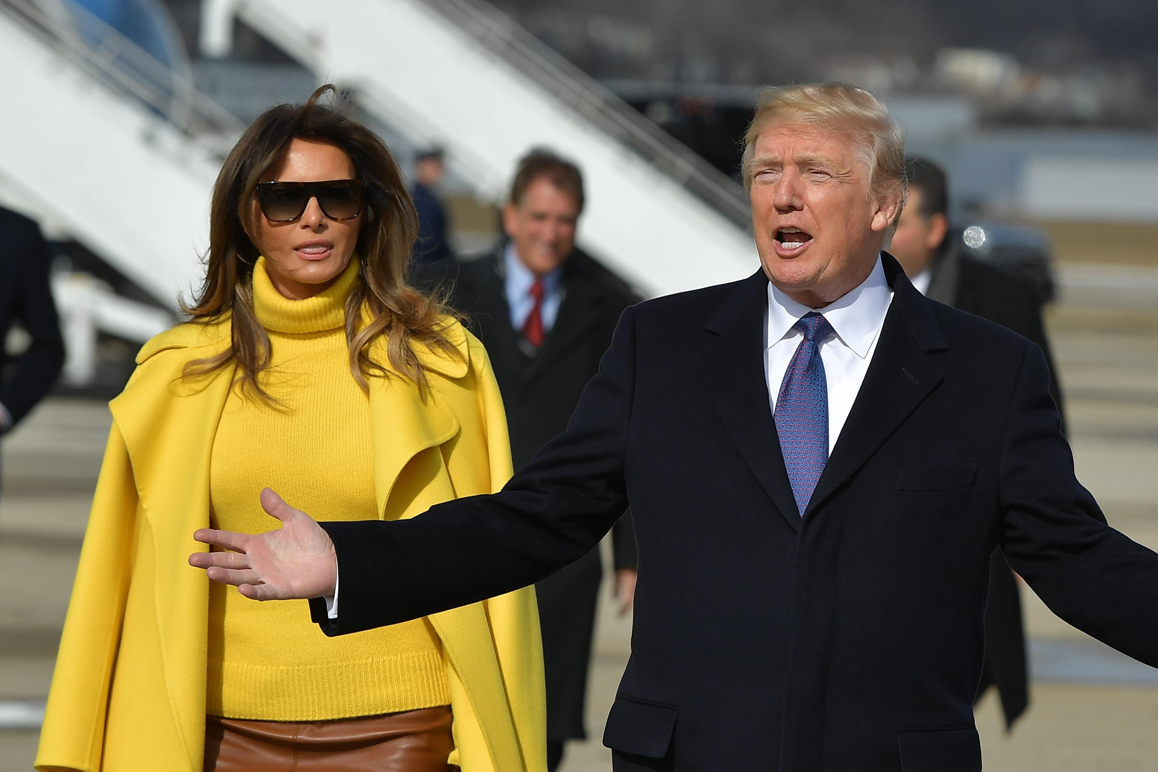 US President Donald Trump and First Lady Melania Trump walk across the tarmac to greet supporters upon arrival at Cincinnati Municipal Lunken Airport in Cincinnati on February 5, 2018. / AFP PHOTO / MANDEL NGAN (Photo credit should read MANDEL NGAN/AFP/Getty Images)