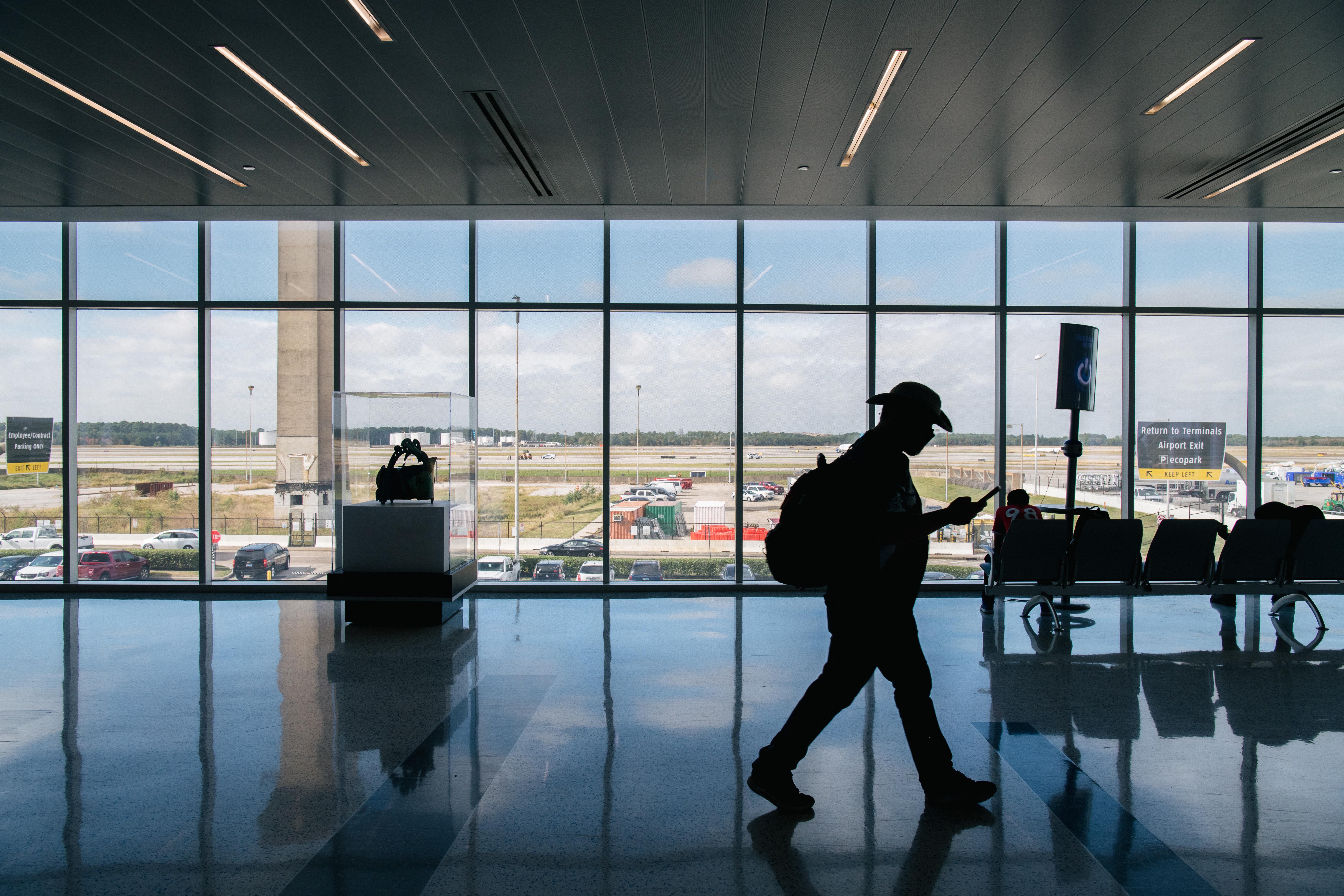 A person in silhouette walking through an airport