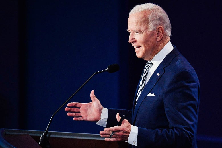 Joe Biden shrugs while standing behind a podium.