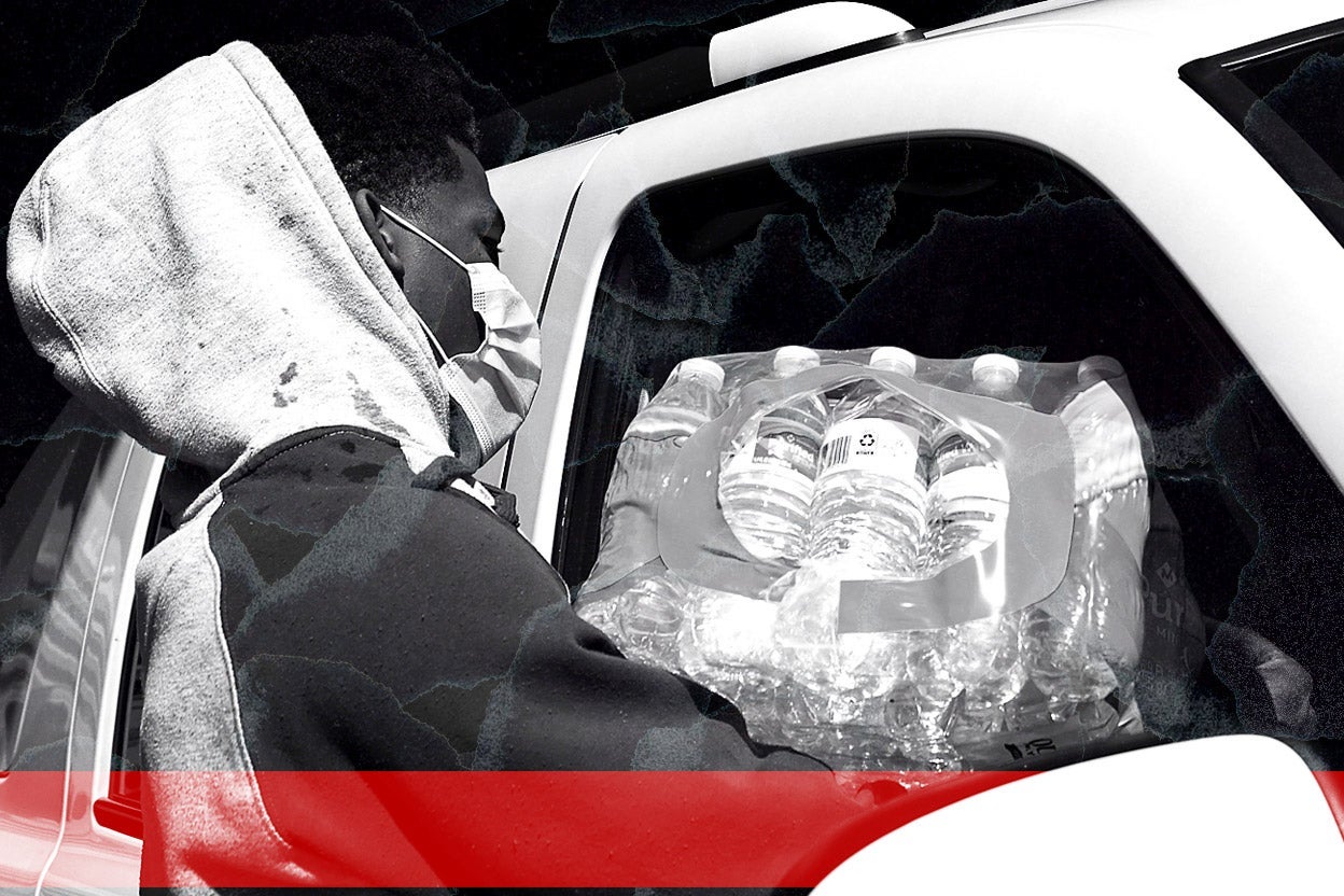 A man loads water bottles into a car.