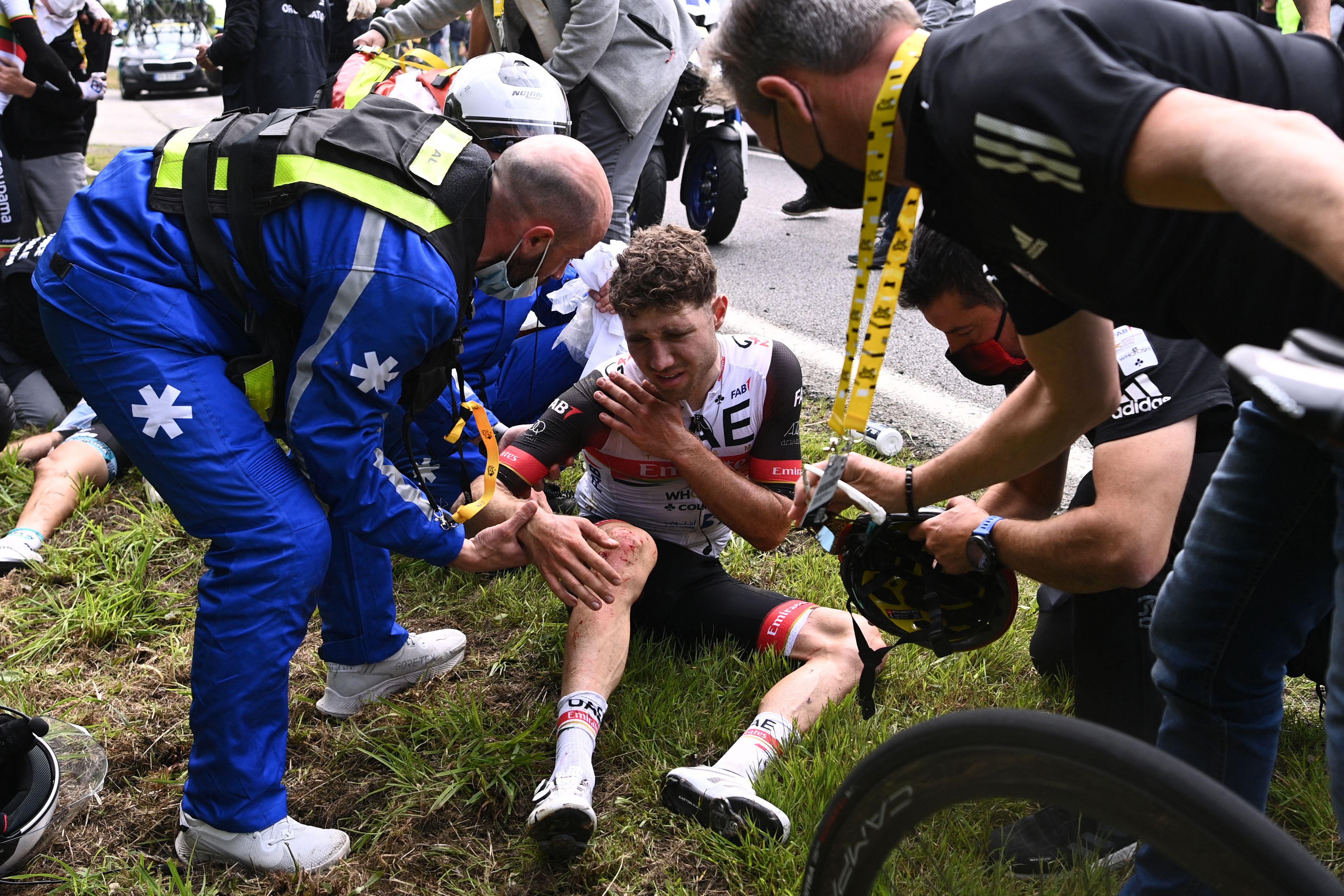 Team UAE Emirates' Marc Hirschi of Switzerland receives medical treatment after crashing during the 1st stage of the 108th edition of the Tour de France cycling race, 197 km between Brest and Landerneau, on June 26, 2021. 
