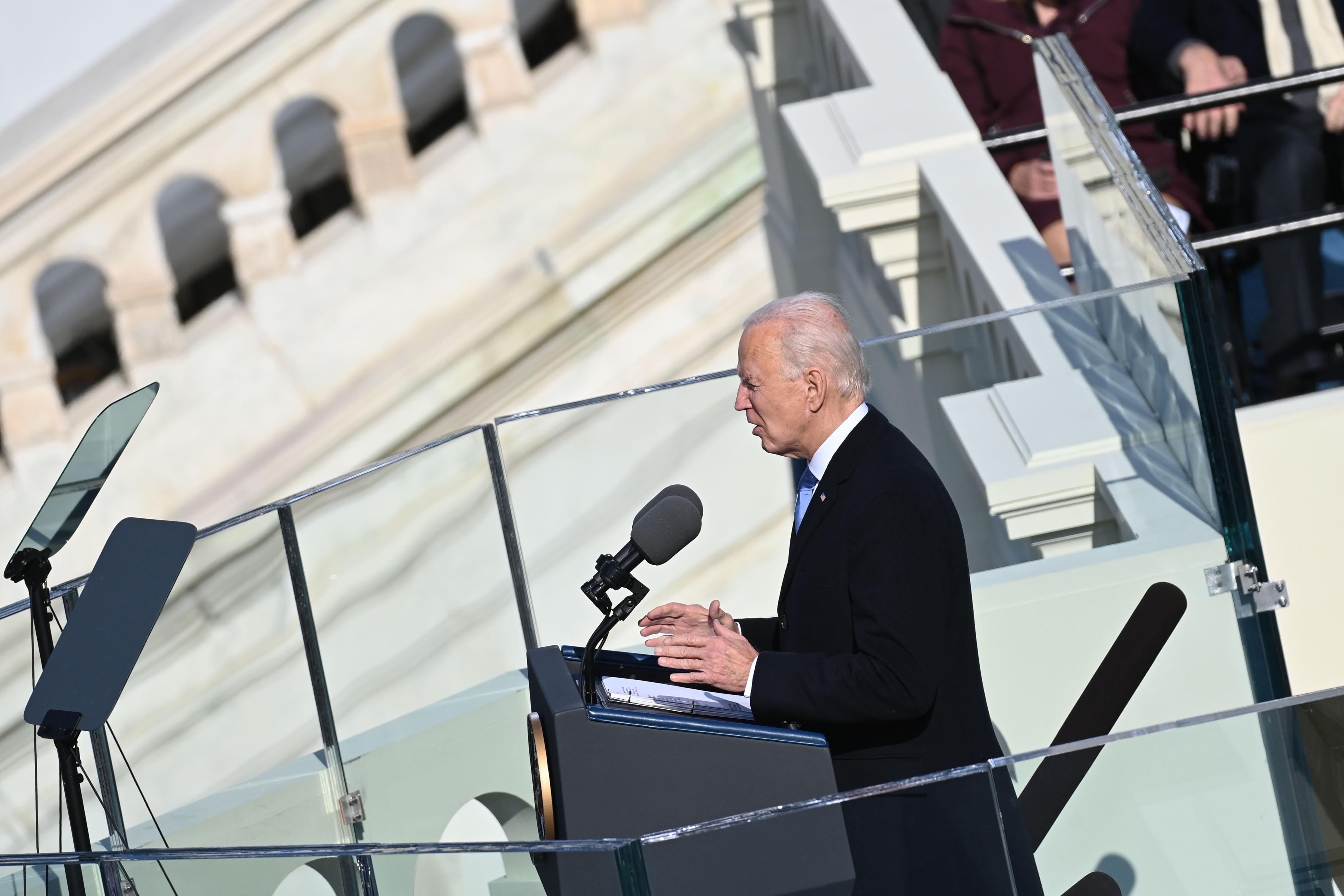 Biden speaking at the lectern seen from the side. 