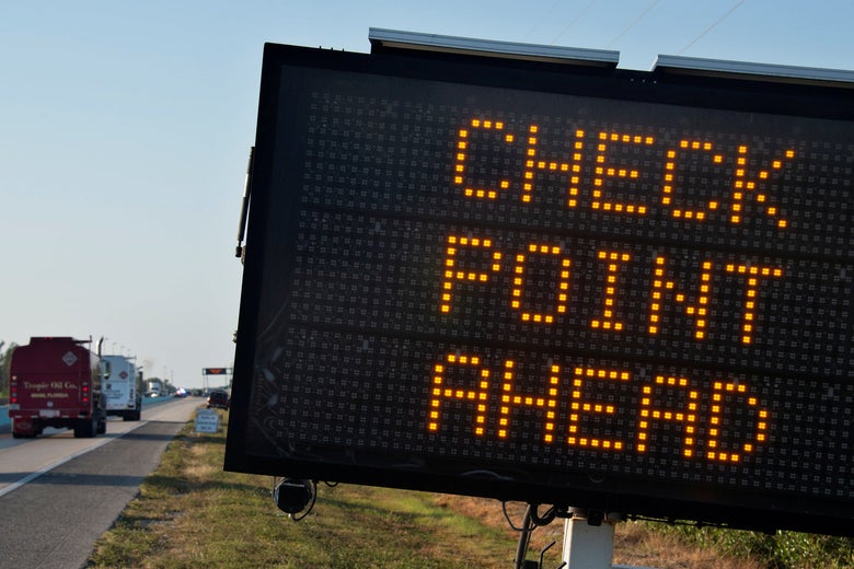 Sign reading "check point ahead" on the side of a highway.