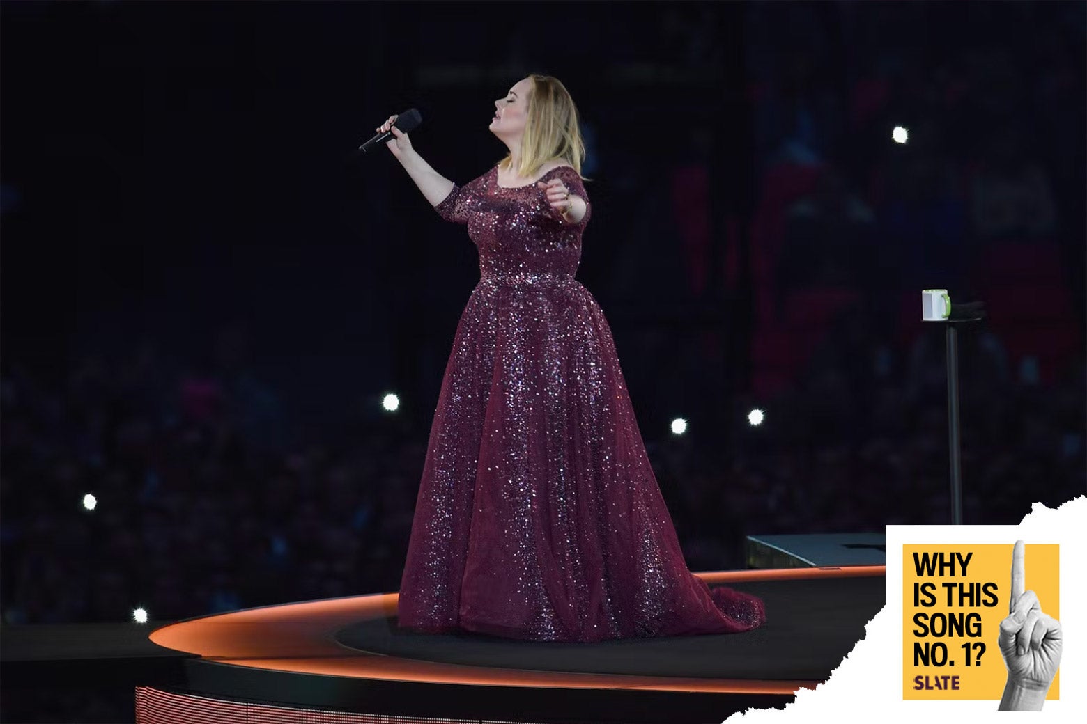 Adele sings on stage in front of a capacity crowd.