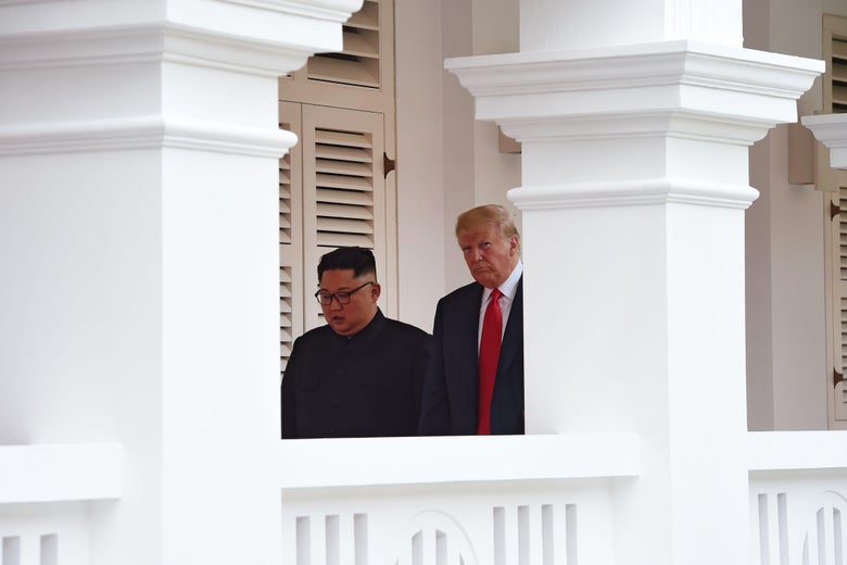 Kim Jong-un and Donald Trump walk side by side.