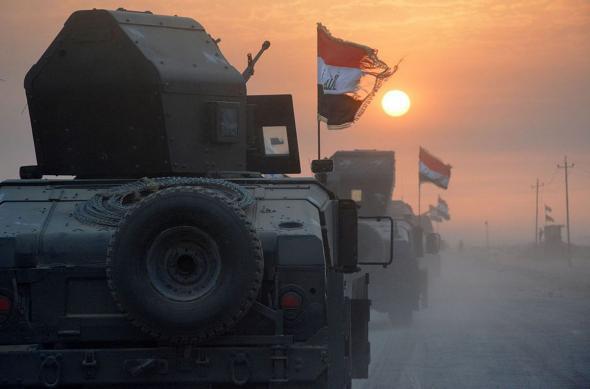 Pro-government forces drive in military vehicles in Iraq's eastern Salaheddin province, south of Hawijah, on October 10, 2016.