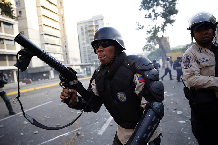 Riot police shoot tear gas as they fight against students during a protest against President Nicolas Maduro's government in Caracas.