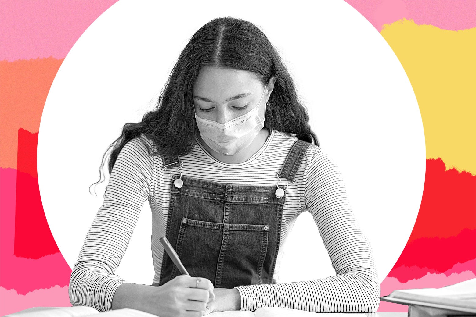 A young teenager wearing a mask doing schoolwork.