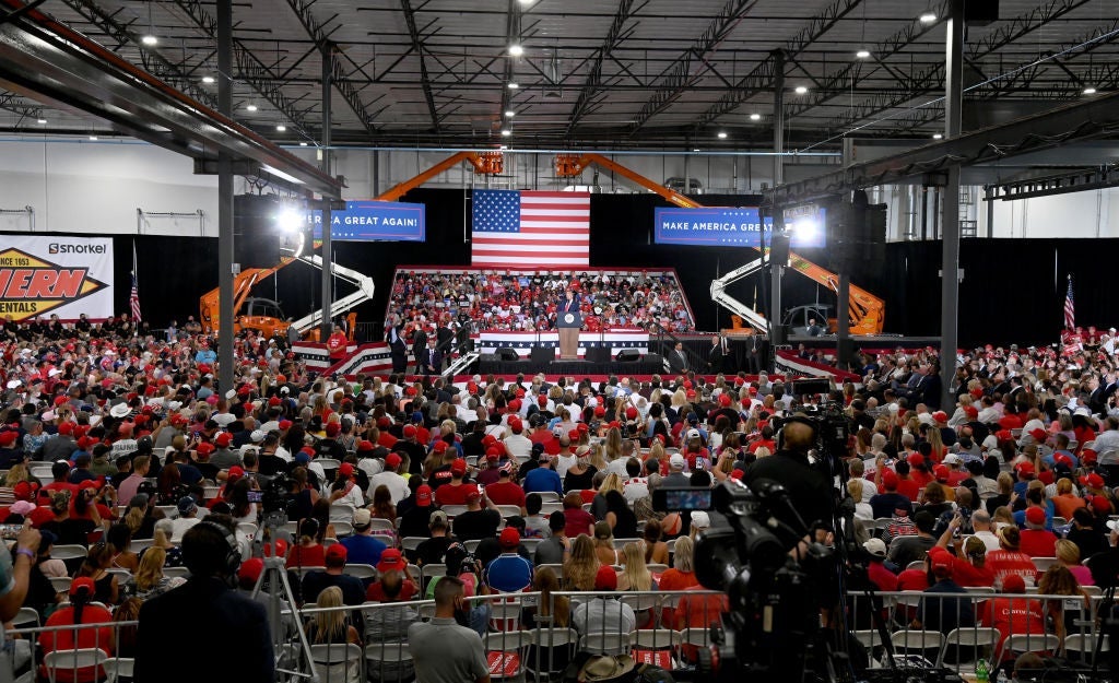 A large crowd gathered in front of and behind the stage on which Trump is speaking.