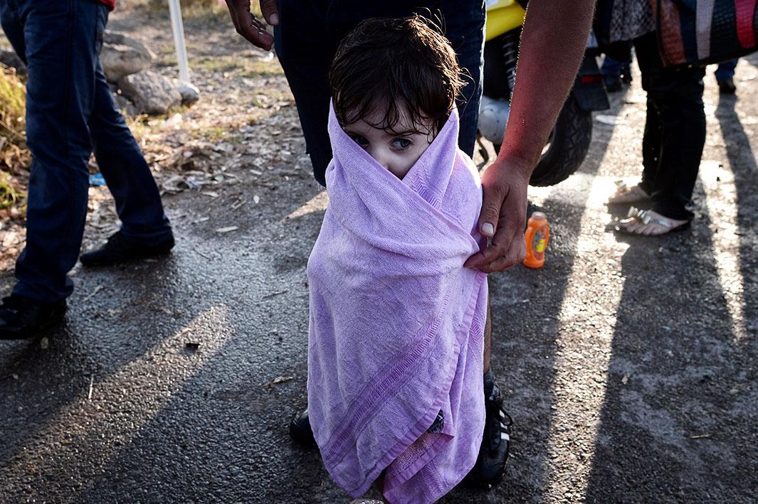 A Syrian father wraps his wet daughter in a towel after their arrival on an overcrowded dinghy to the coast of the southeastern Greek island of Kos on Aug. 15, 2015