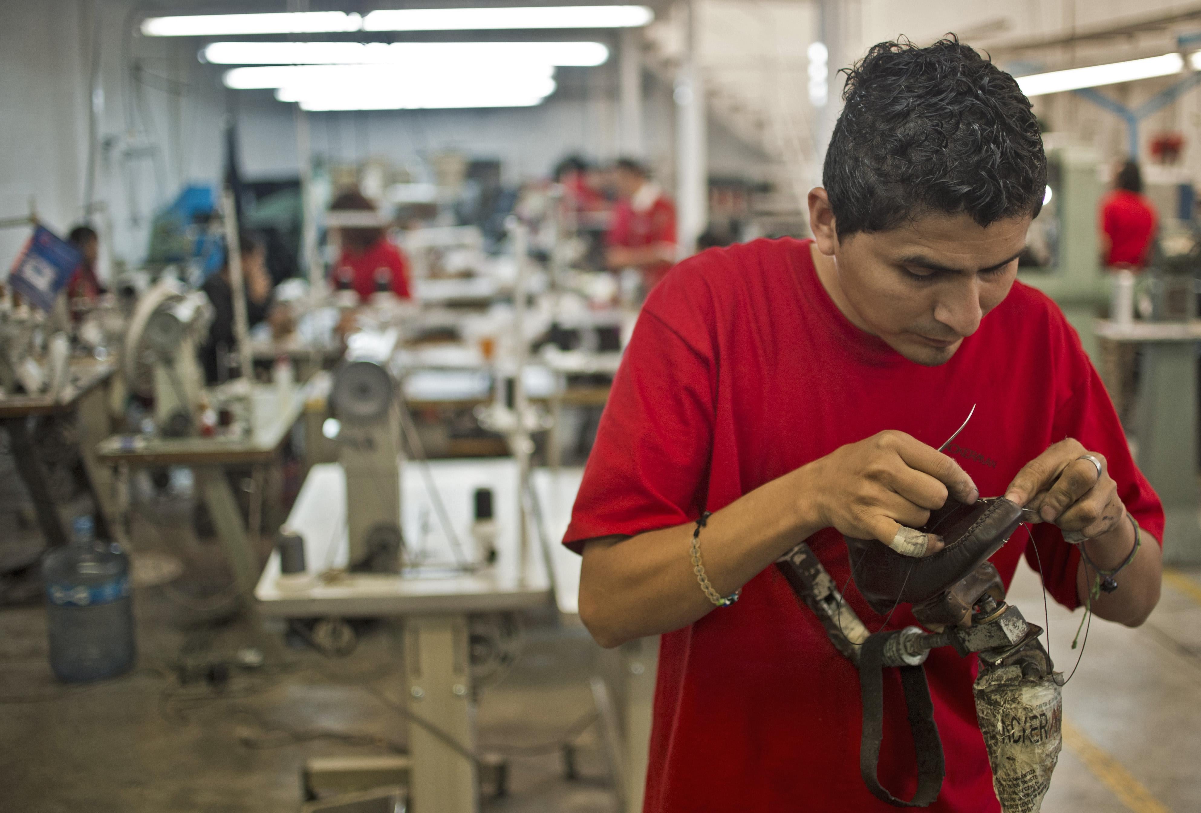 A worker sews a shoe in the factory where the shoes given to Pope Benedicto XVI during his 2012 visit to Mexico were made, in Leon, Guanajuato State, on March 1, 2013.