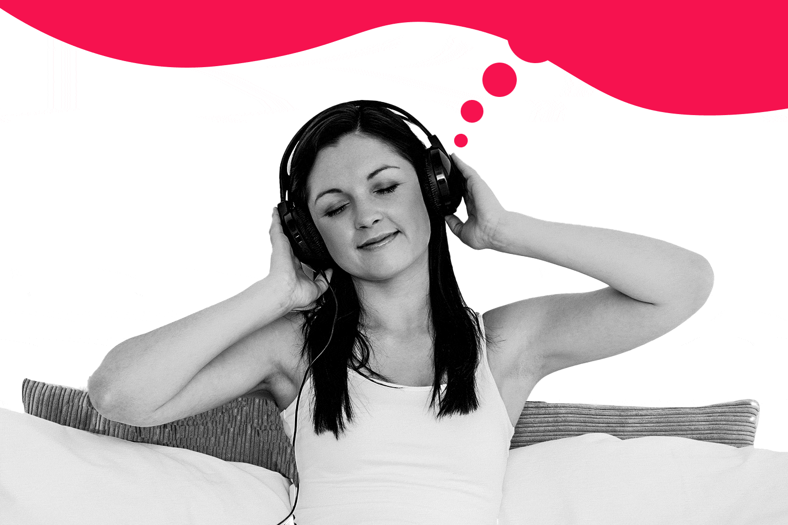 Woman with headphones on in bed.
