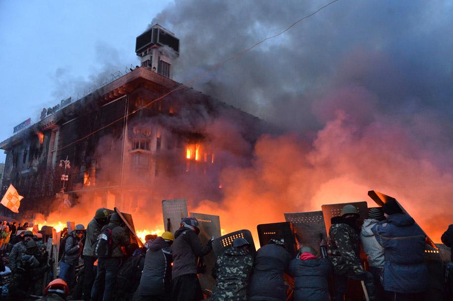 Protesters protect themselves behind shields as they clash with the police in Independence Square in Kiev on Feb. 19, 2014. 