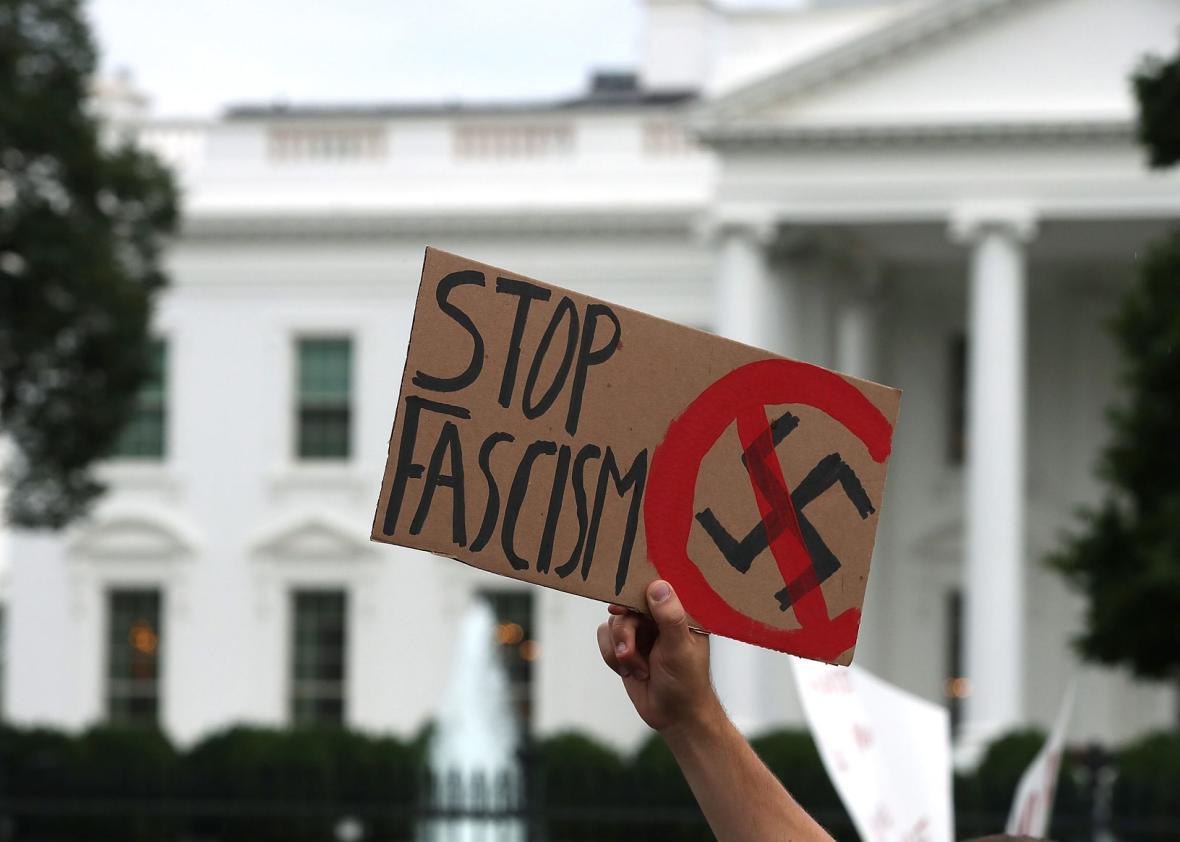 A man holds up a sign during a protest against racism gathered in front of the White House, on August 14, 2017 in Washington, DC. 
