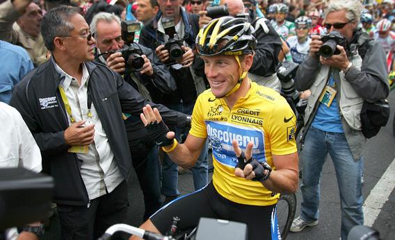 Lance Armstrong of the USA riding for the Discovery Channel team, shows seven fingers (meaning seven victories).