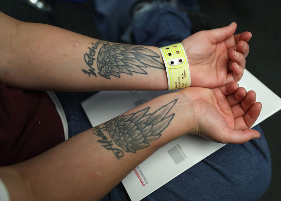 A female prisoner shows off her tattoos.