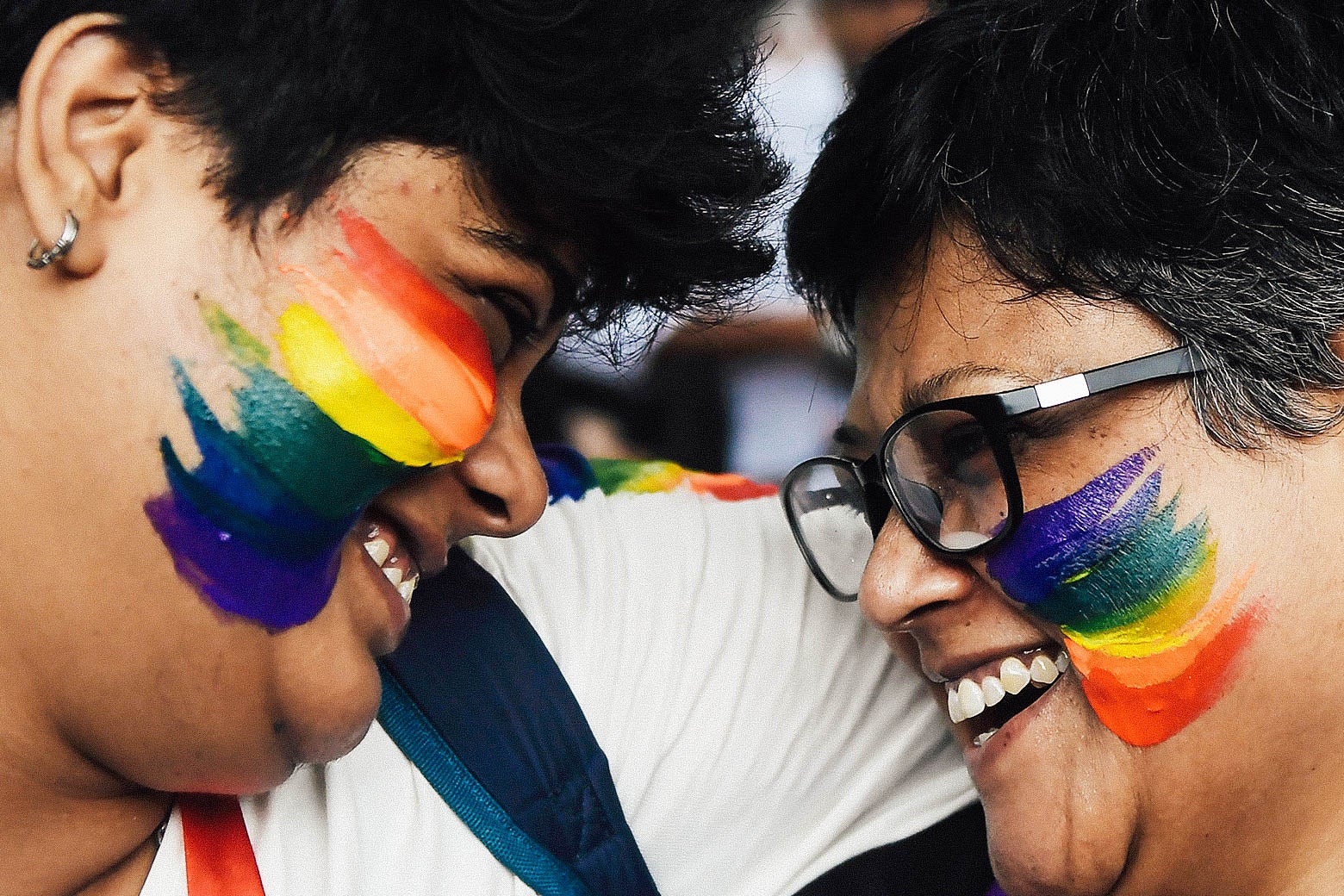 Two Indian supporters of the LGBTQ community celebrate with smiles and rainbow flag face paint on Thursday.