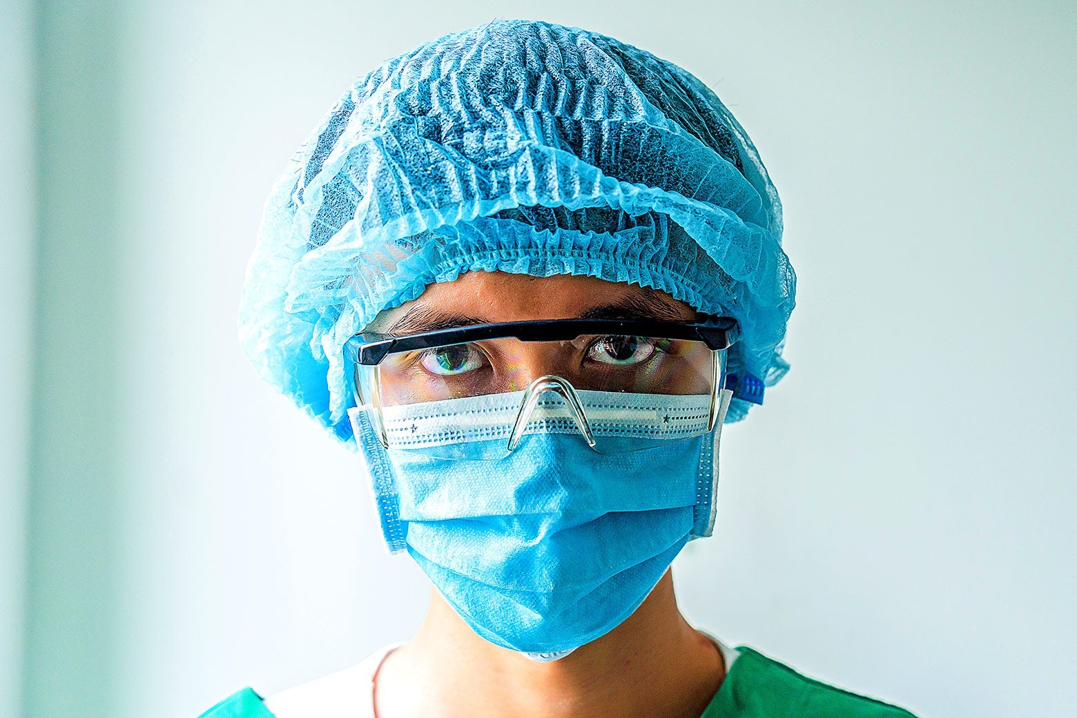 A male nurse wearing goggles and a face mask