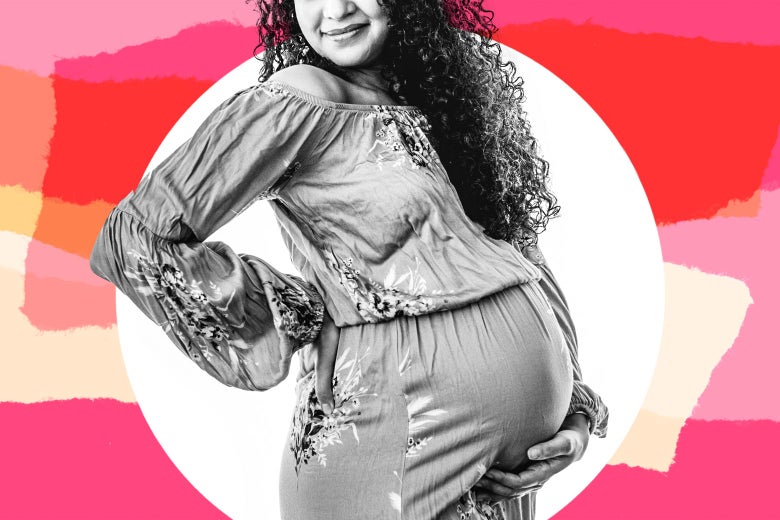 Thirtysomething woman smiling and holding her pregnant belly