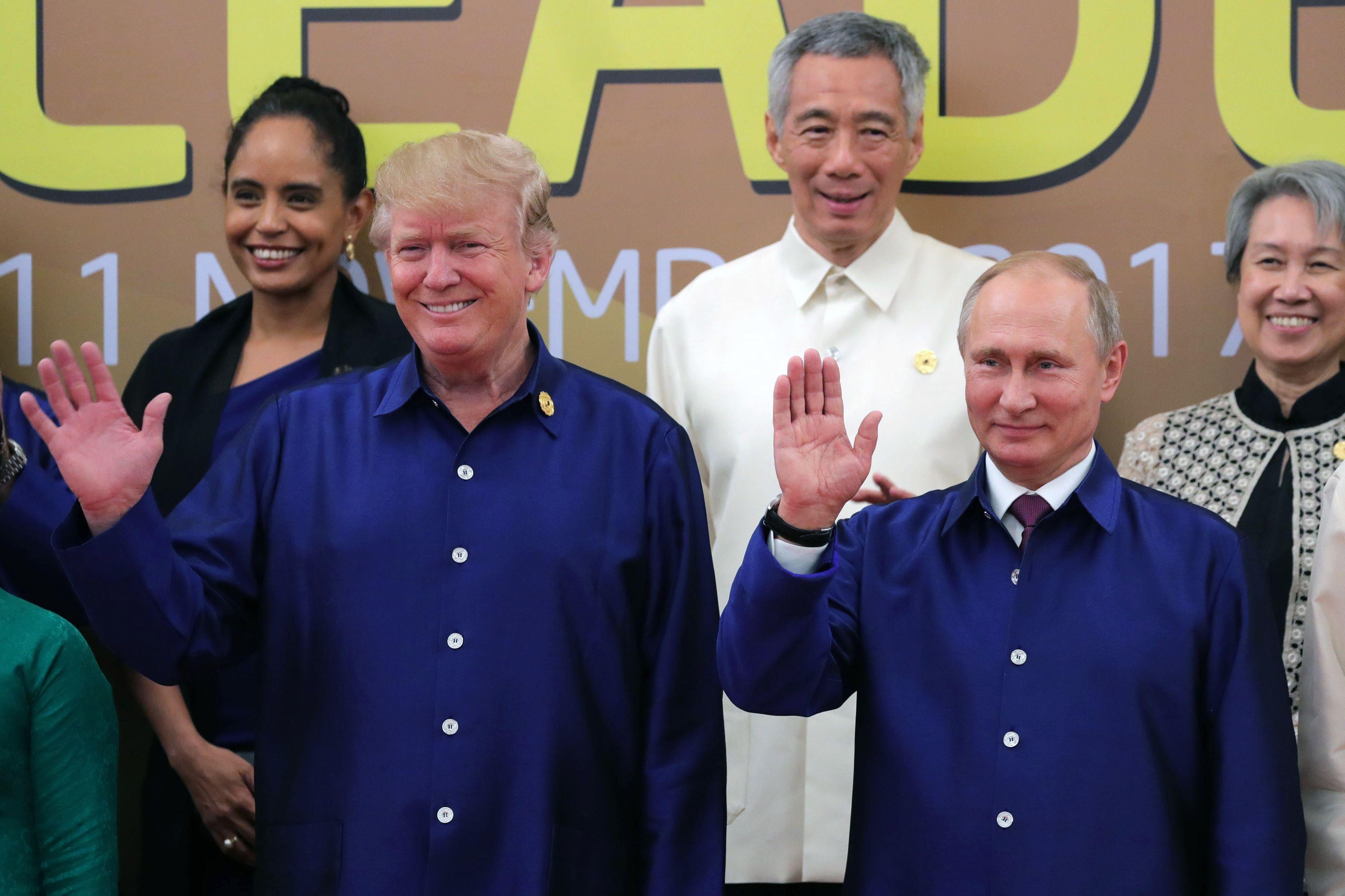 U.S. President Donald Trump and Russian President Vladimir Putin wave during a group photo of APEC leaders