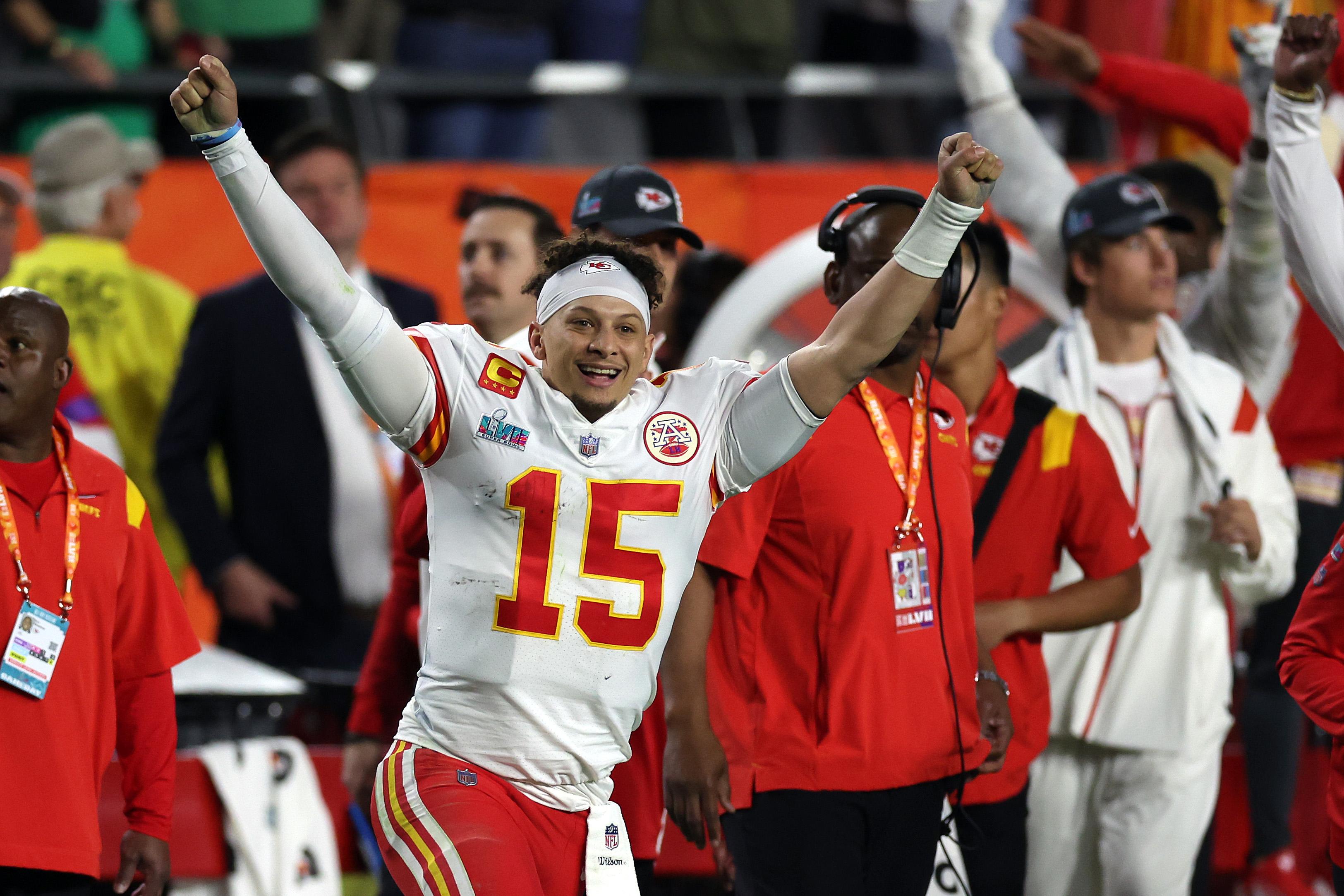 Mahomes smiles, raises his arms, and running onto the field