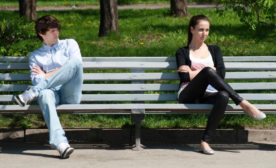 A couple breaks up on a bench.