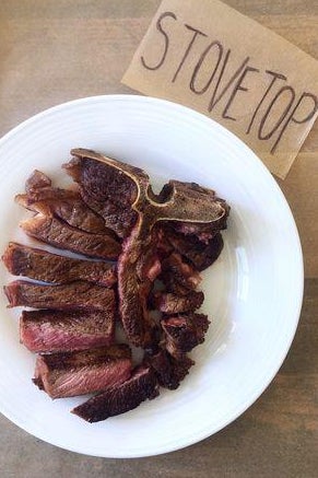 A T-bone steak on a plate next to a sign labelled "Stovetop."