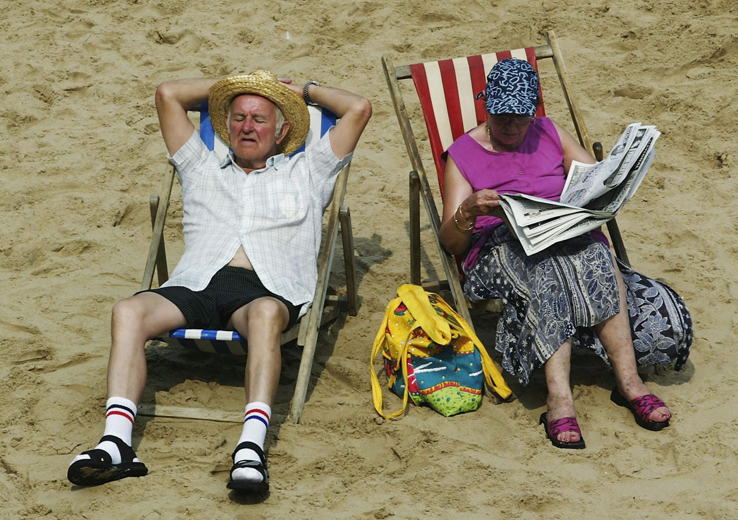 A couple sits on the beach.