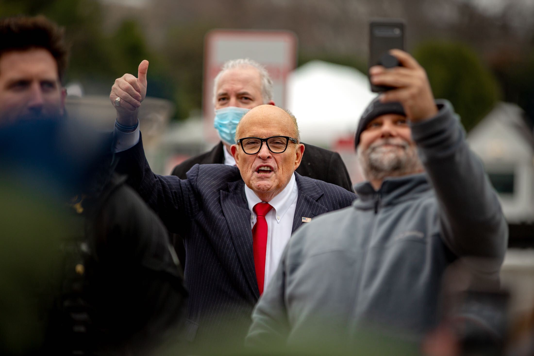 A Trump supporter snaps a selfie with Rudy Giuliani.