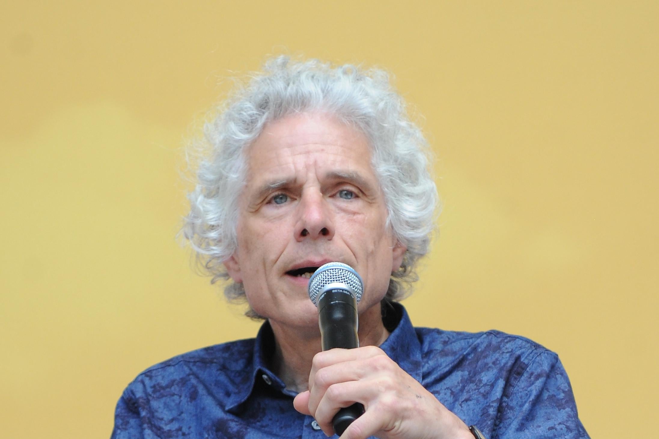 Steven Pinker holds a microphone.