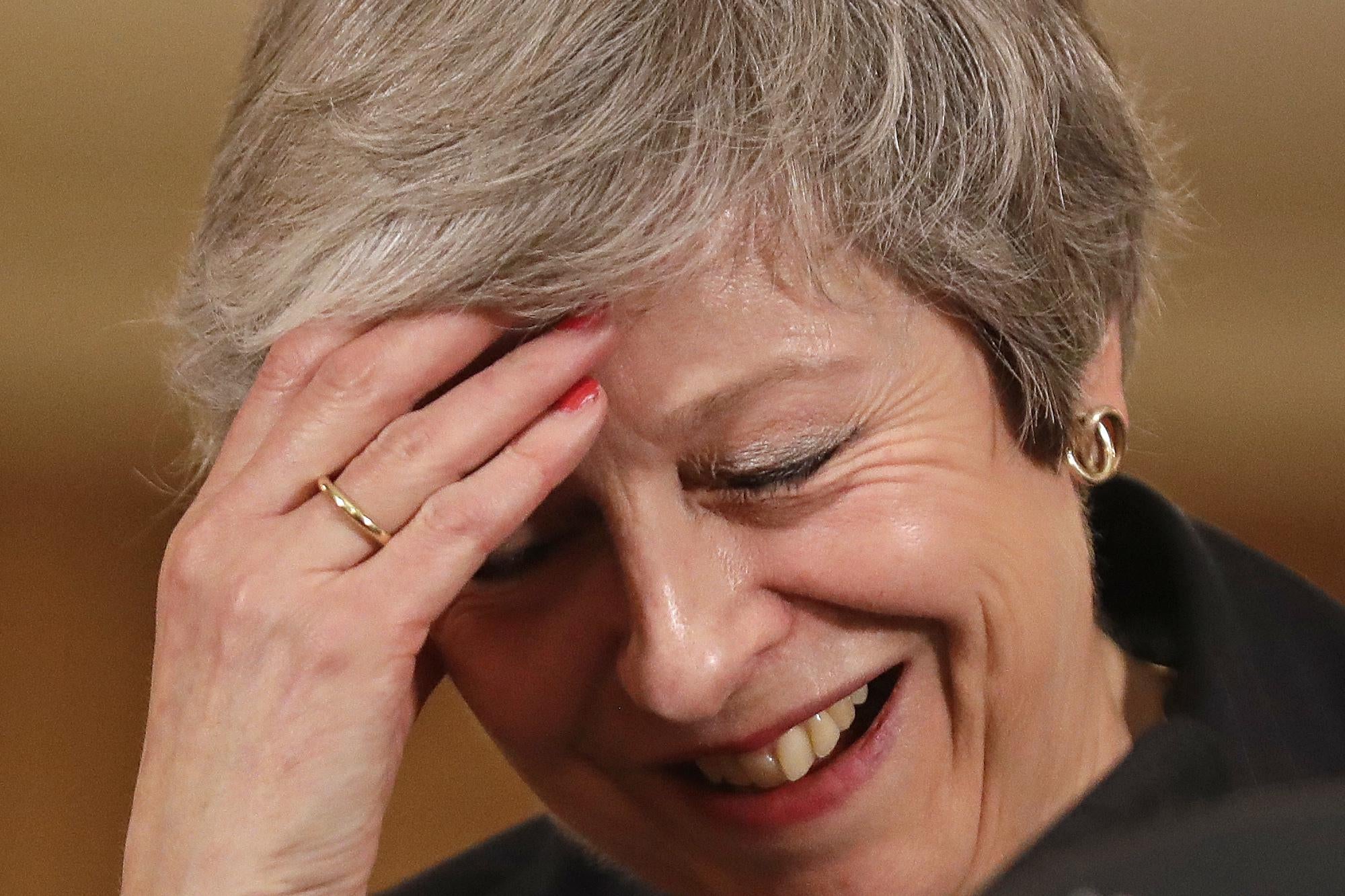 Britain's Prime Minister Theresa May laughs as she speaks during a press conference inside 10 Downing Street on November 15, 2018.