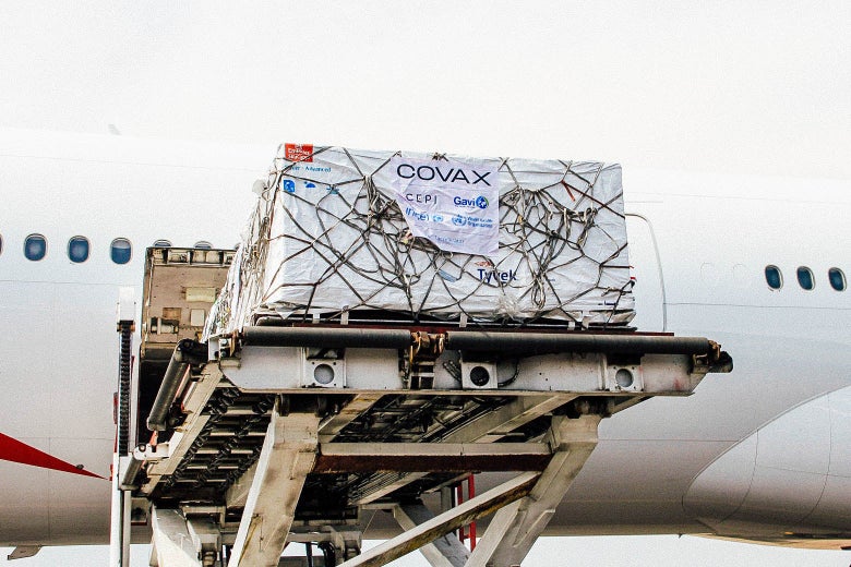 Large boxes of vaccine labeled COVAX are unloaded from an airplane