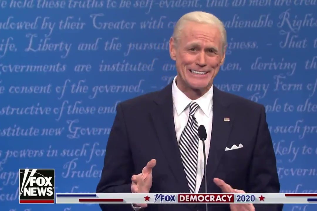 Jim Carrey as Joe Biden, standing in front of a debate podium, smiling broadly.